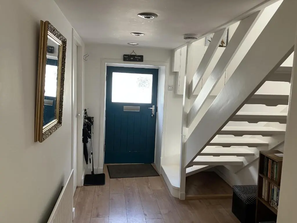 a hallway with a blue door and stairs at 3 Dunrobin Street in Tain