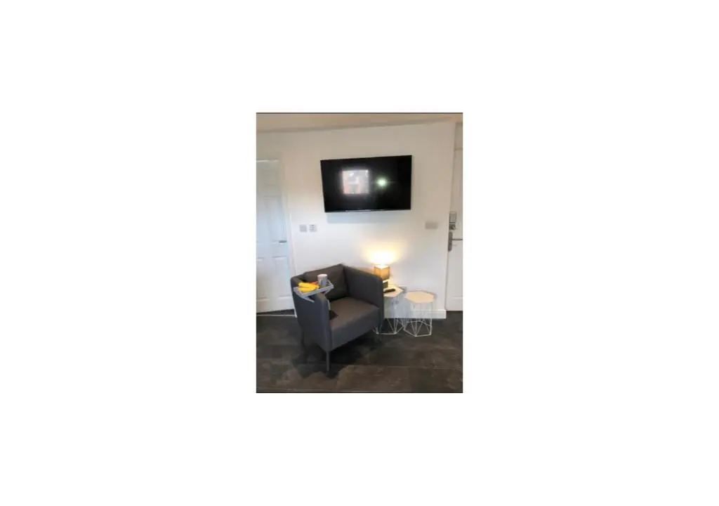 a living room with a couch and a tv at Grey Apartment in Inverness