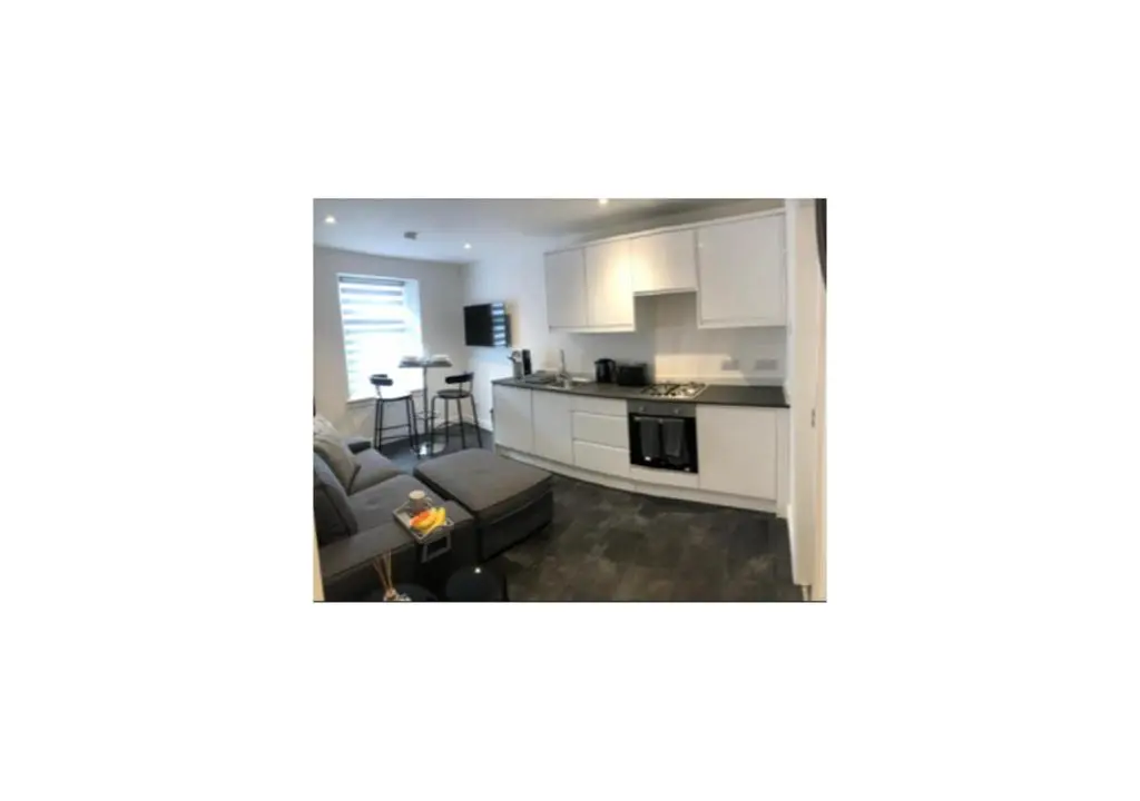 a view of a kitchen and a living room at Grey Apartment in Inverness