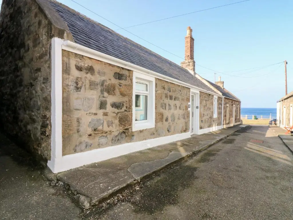 a stone building with a window on the side of it at Seaspray Cottage in Buckie