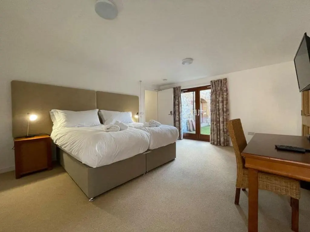 a bedroom with a bed and a desk and a computer at Balloan Steading East in Dornoch