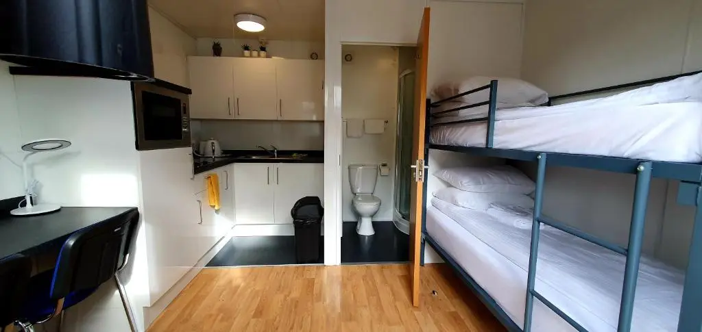 two bunk beds in a small room with a kitchen at Kingussie Garden Cabins in Kingussie