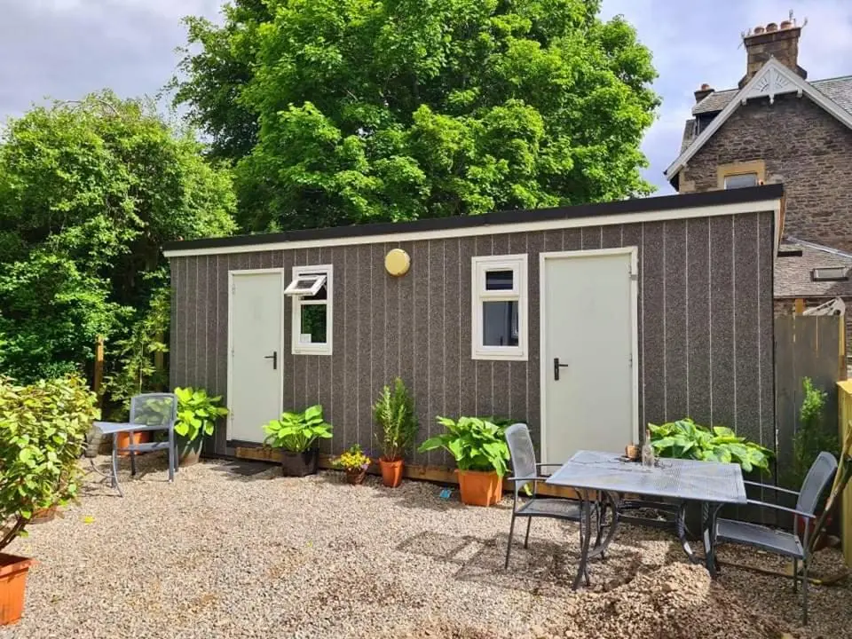 a small shed with a table and chairs at Kingussie Garden Cabins in Kingussie