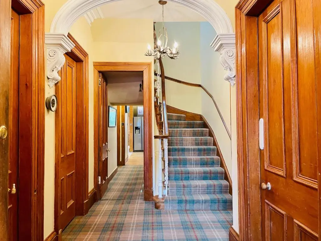 a hallway with a staircase in a house at Ladies Lodge Inverness in Inverness