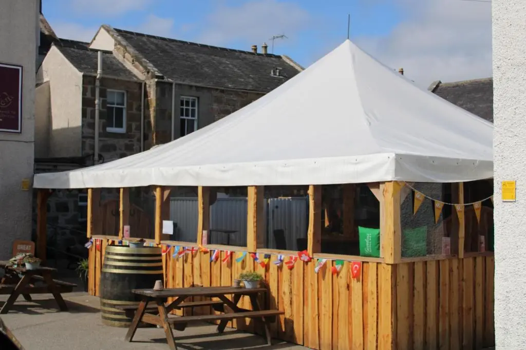 a white tent in front of a wooden fence at The Aberlour Hotel in Aberlour