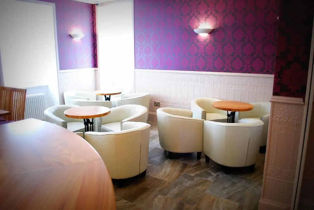a restaurant with white chairs and tables and purple walls at The Aberlour Hotel in Aberlour