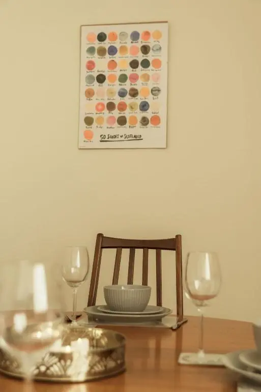 a table with a plate and two wine glasses on it at No 4 the Highlands in Strathpeffer