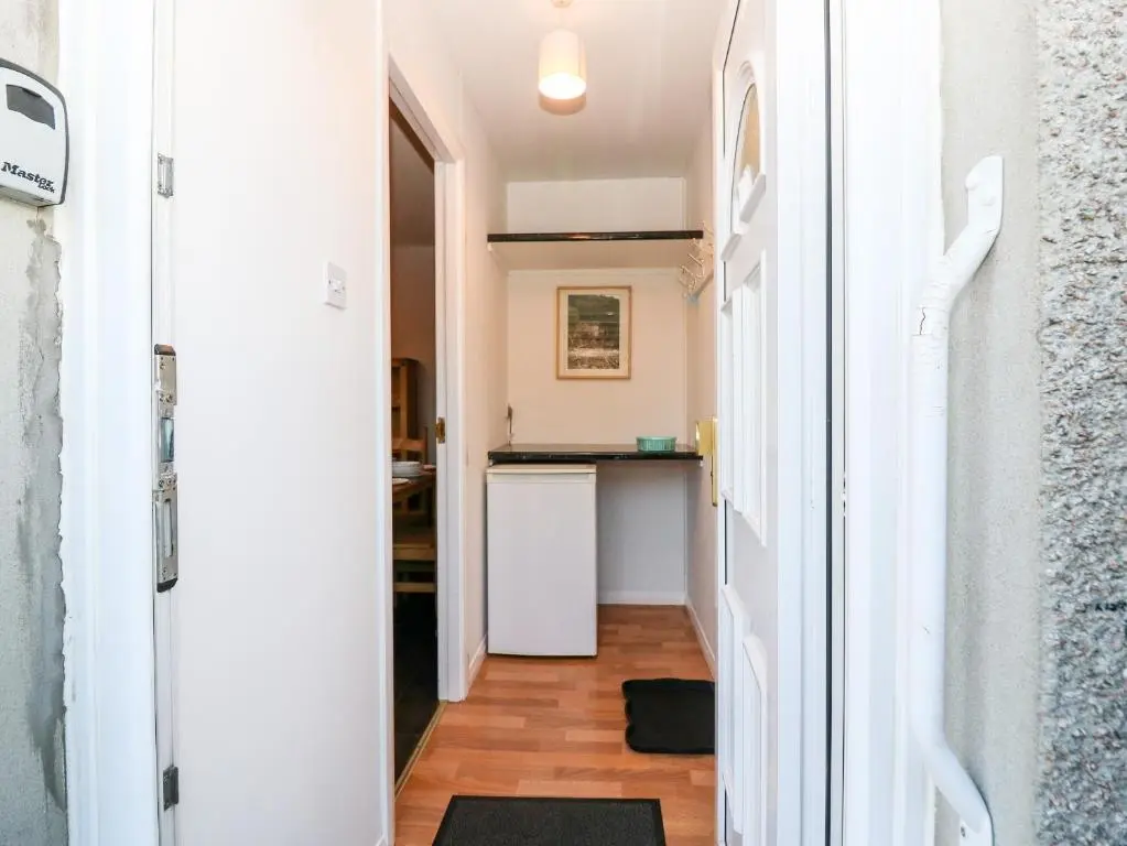 a hallway leading to a kitchen with a white refrigerator at 10 Annesley Park in Banchory