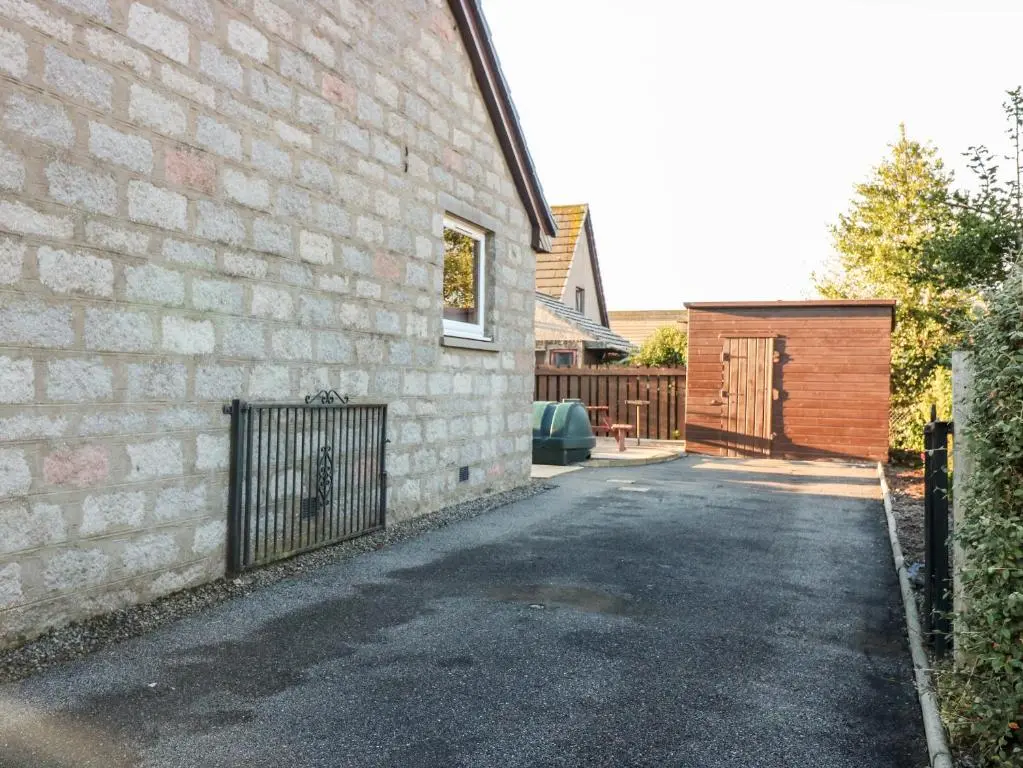 a brick building with a gate next to a driveway at 10 Annesley Park in Banchory