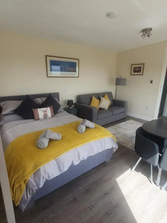 a bedroom with a large bed and a couch at Castle Shieling in Latheron