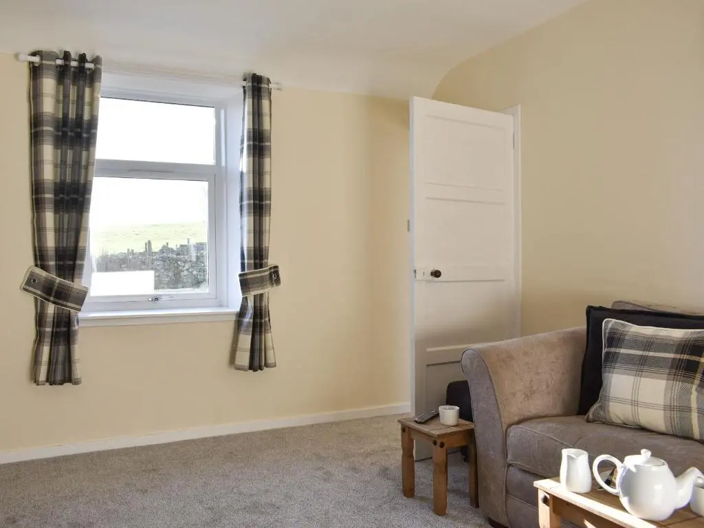 a living room with a couch and a window at Benwells Holiday Cottage in Maud