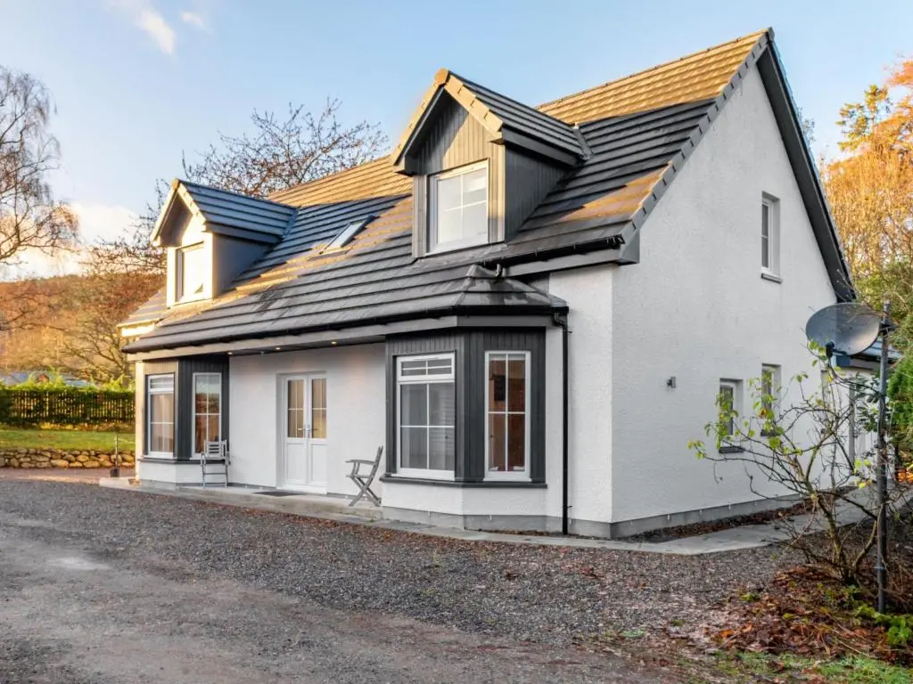 a white house with a black roof at Holiday Home Loch Ness House by Interhome in Drumnadrochit