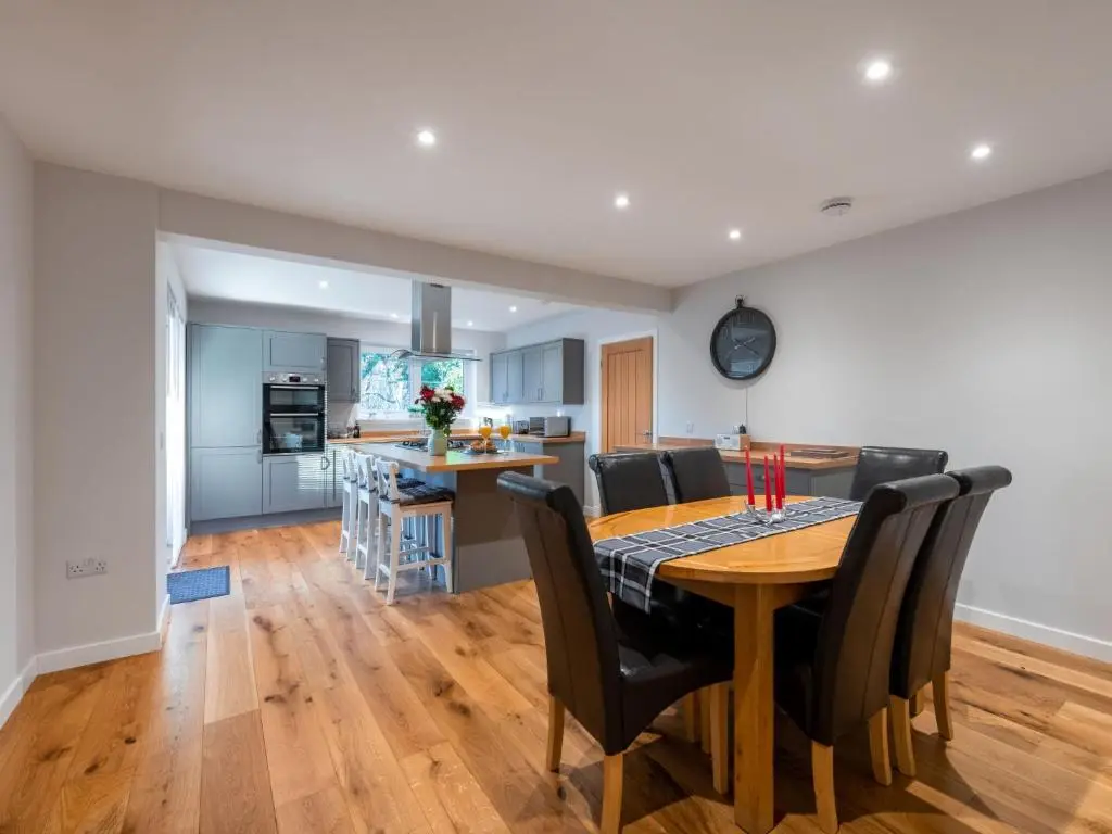 a kitchen and dining room with a wooden table and chairs at Holiday Home Loch Ness House by Interhome in Drumnadrochit