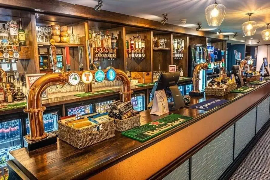 a bar with wicker baskets on the counter at The Hudson @ Silversands in Lossiemouth