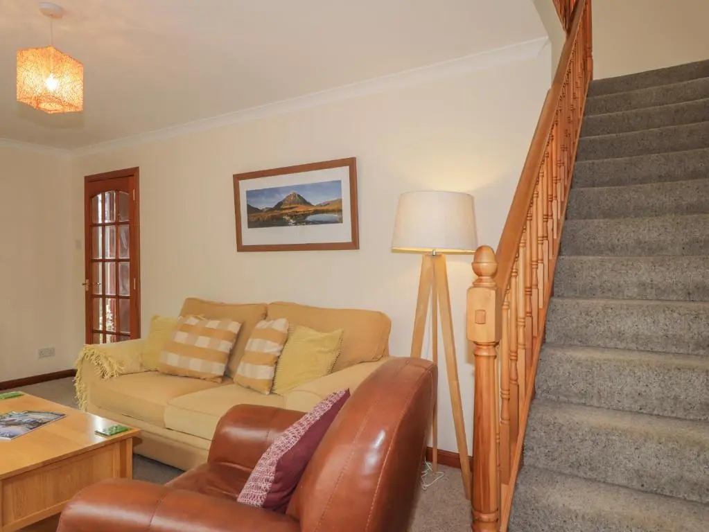 a living room with a couch and a staircase at Iola in Inverness