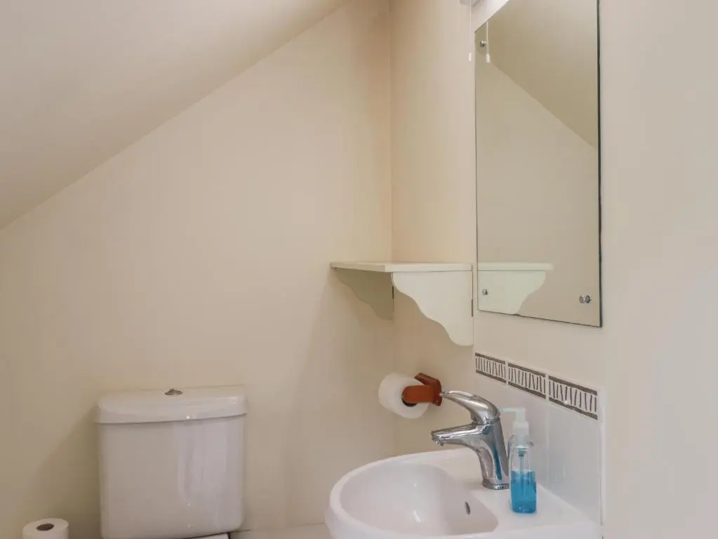 a white bathroom with a sink and a toilet at Iola in Inverness