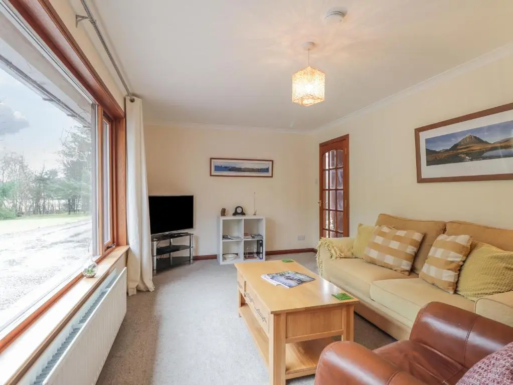 a living room with a couch and a tv at Iola in Inverness