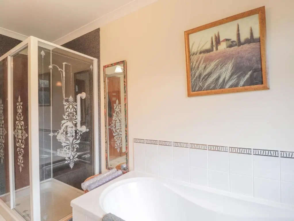 a bathroom with a tub and a picture on the wall at Iola in Inverness