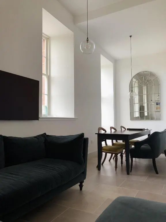 a living room with a black couch and a table at 38 Great Glen Townhouse Inverness in Inverness