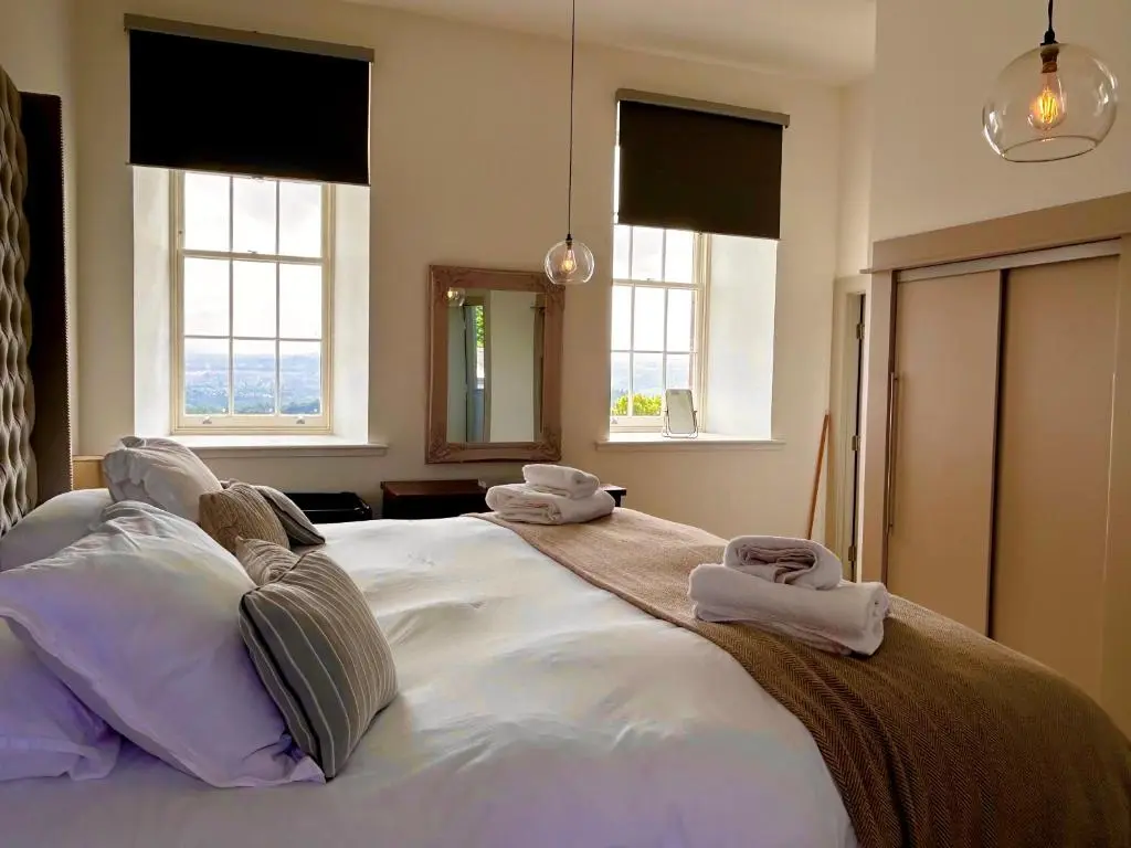 a bedroom with a large bed with towels on it at 38 Great Glen Townhouse Inverness in Inverness