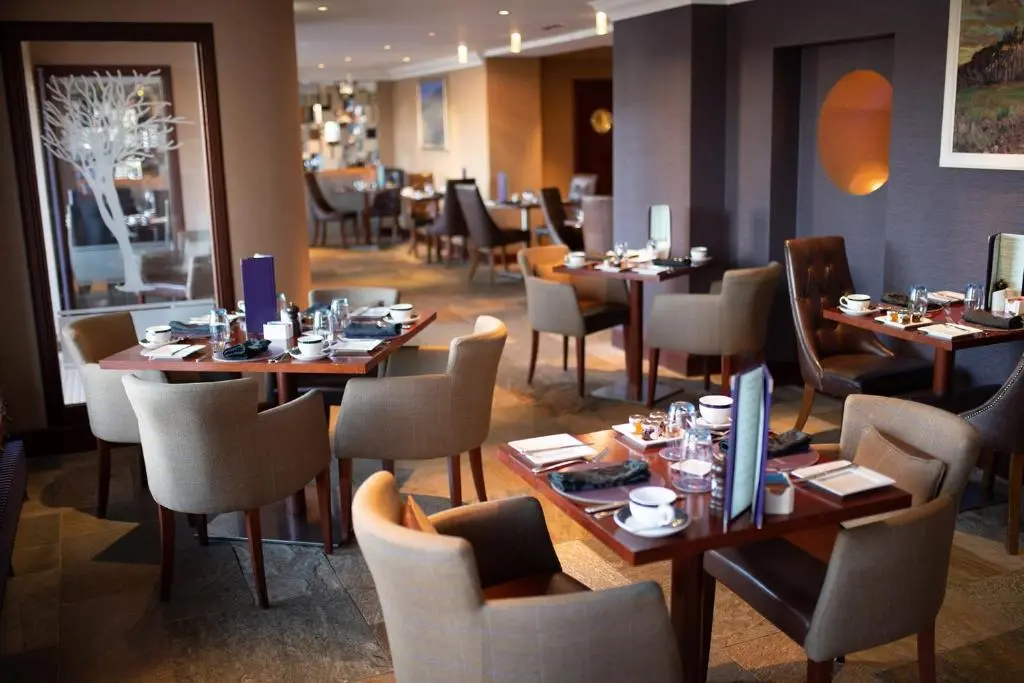 a dining room with tables and chairs in a restaurant at The Mansefield Hotel in Elgin
