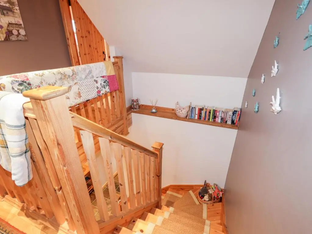a baby room with a crib and a book shelf at Bogindour Cottage in Muir of Ord
