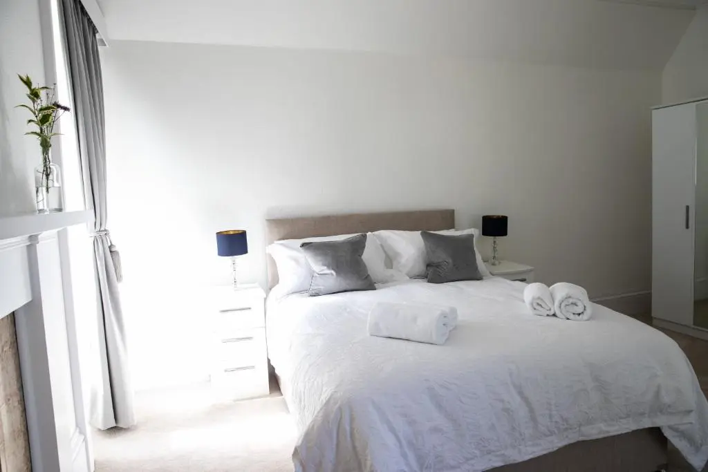 a bedroom with a white bed with towels on it at Whitecraigs in Elgin
