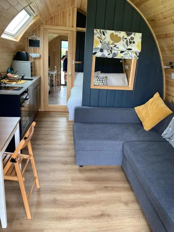 a living room with a couch in a tiny house at Robins Nest Glamping Pod with Hot Tub in Keith