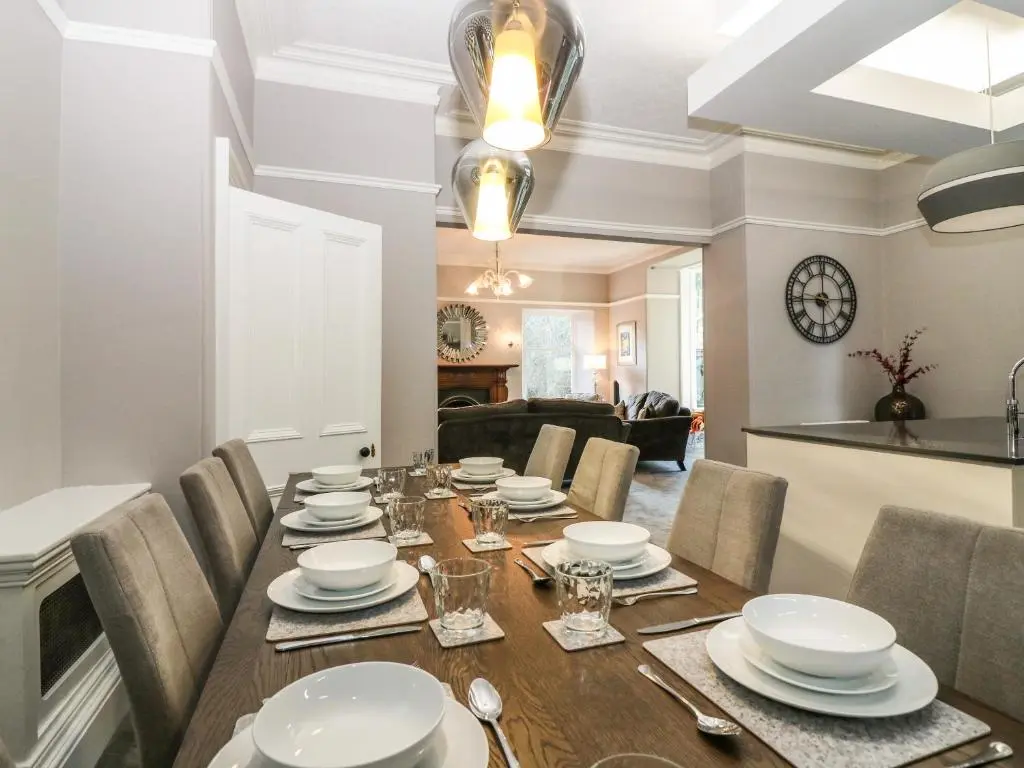 a dining room with a wooden table and chairs at Mavisbank in Peterhead