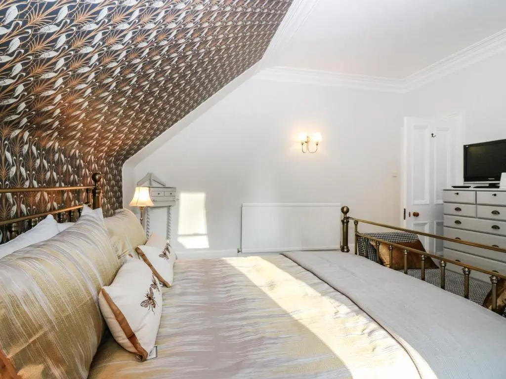 a bedroom with a large bed and a television at Mavisbank in Peterhead