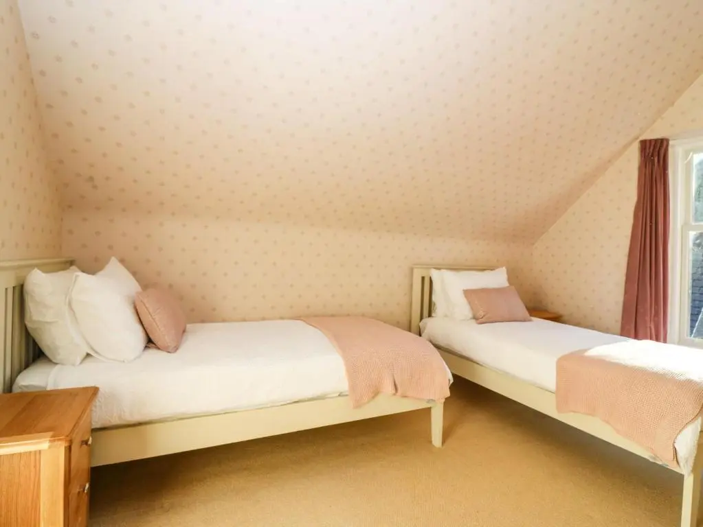 a bedroom with two beds with pink and white sheets at Mavisbank in Peterhead