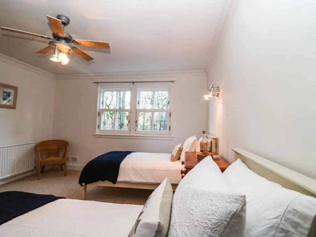 a bedroom with two beds and a ceiling fan at Mavisbank in Peterhead