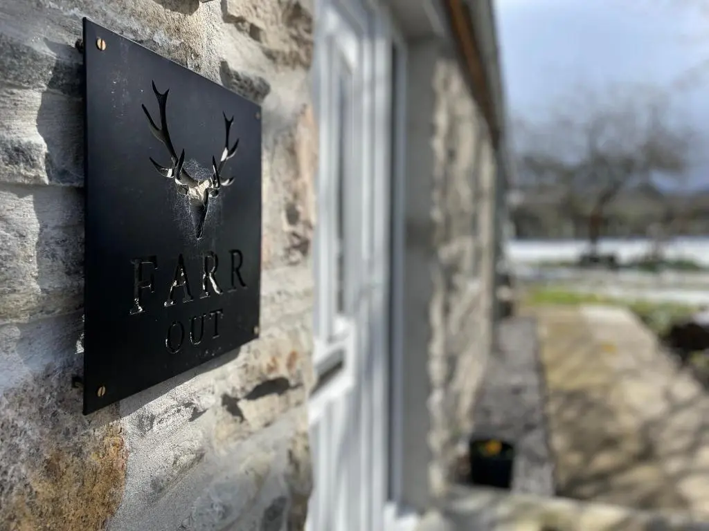 a sign on a building with a deer sign on it at Farr Out in Farr