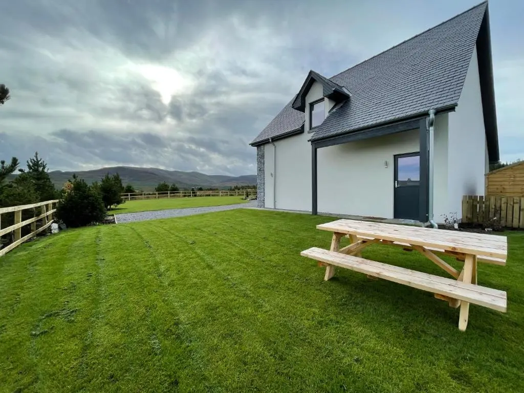a picnic table in front of a white building at Little Thistle Apartment in Whitebridge