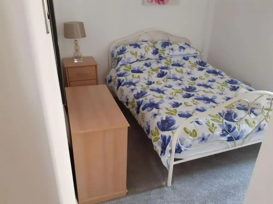 a bedroom with a bed and a wooden table at Lossiemouth Seaside Flat in Lossiemouth