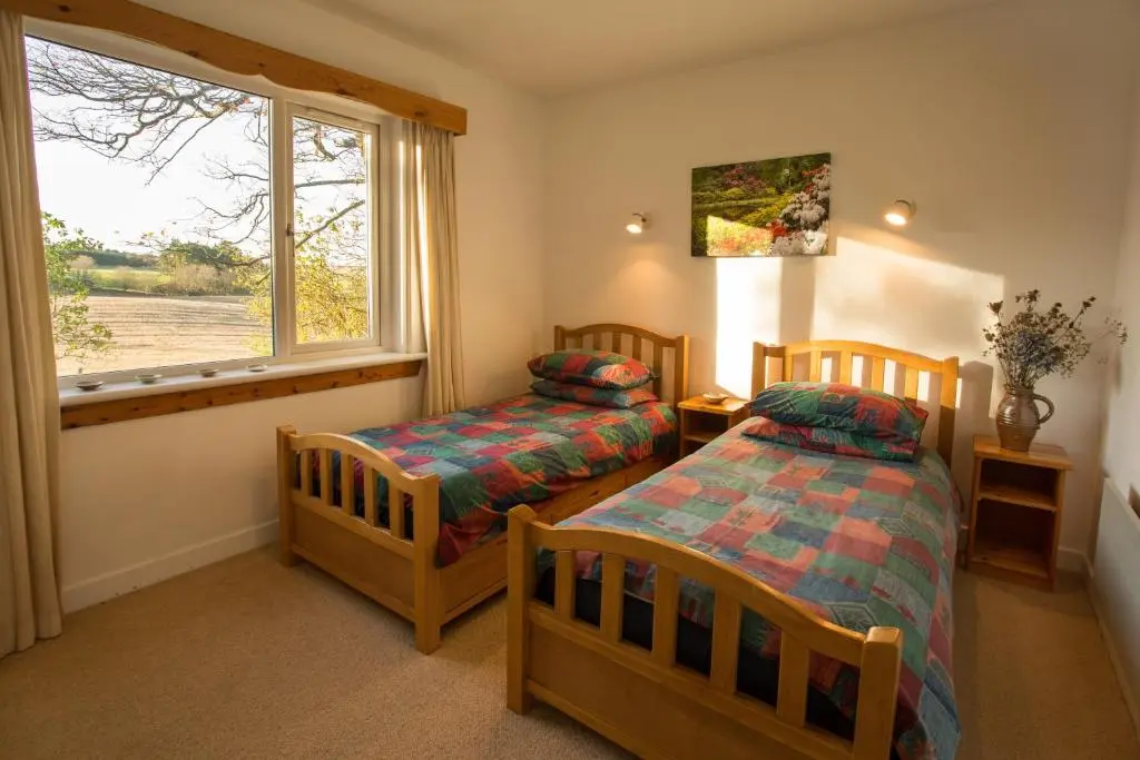 a bedroom with two beds and a window at The White Cottage in Elgin