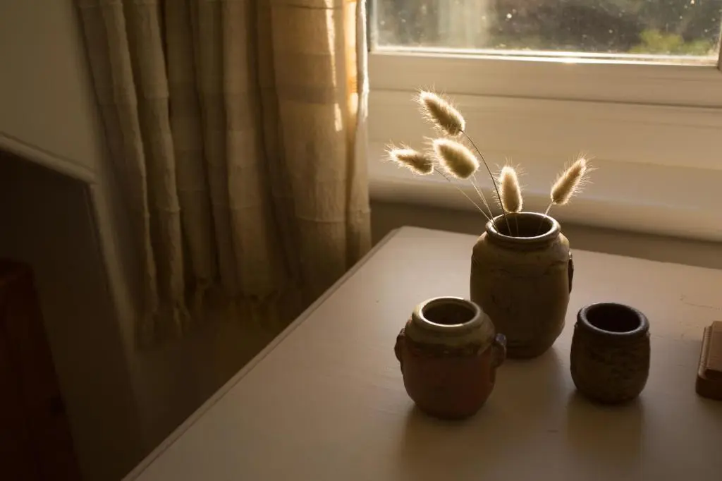 three vases sitting on a table next to a window at The White Cottage in Elgin