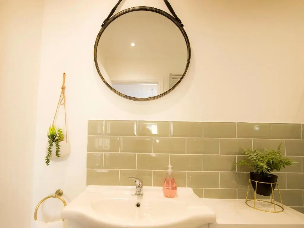 a bathroom with a sink and a mirror on the wall at Sandpiper Cottage in Buckie