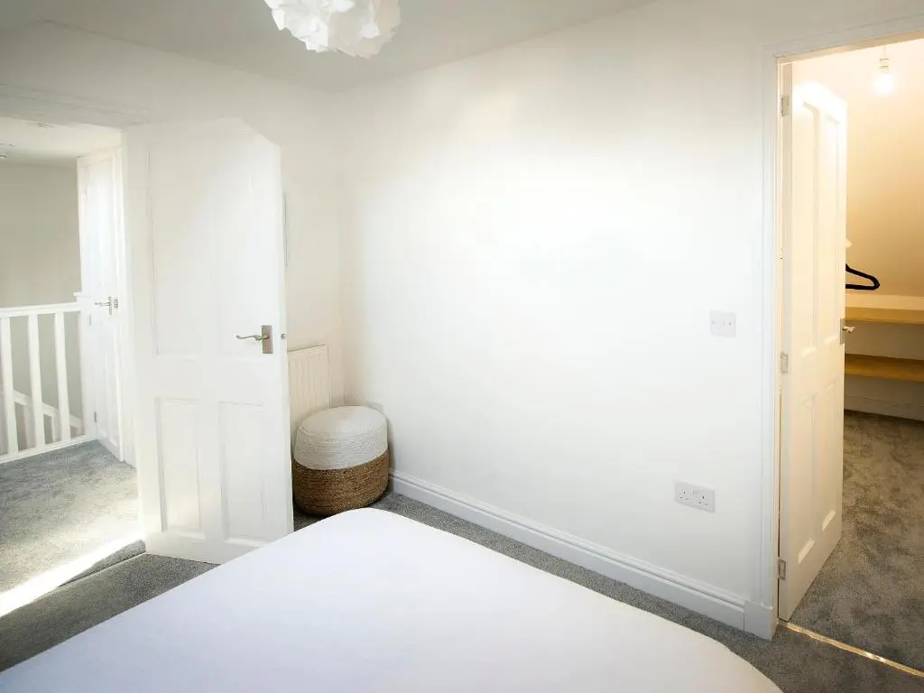 a white room with a door and a toilet at Eider Cottage in Buckie