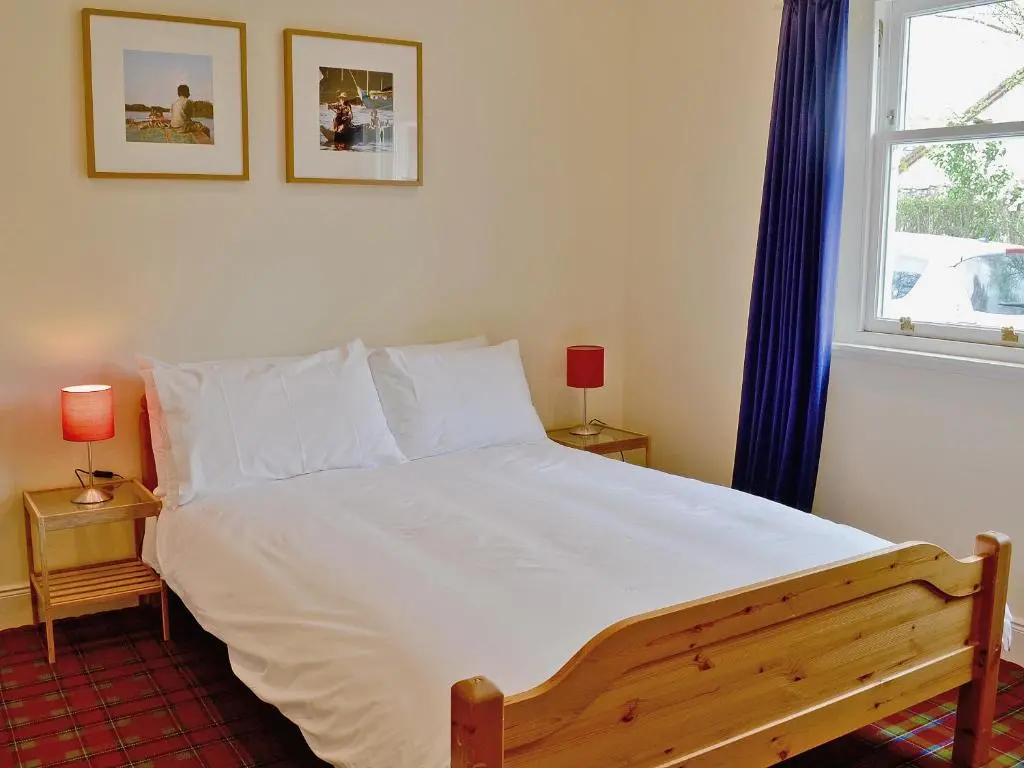 a bedroom with a large white bed and a window at Haugh House in Aberlour