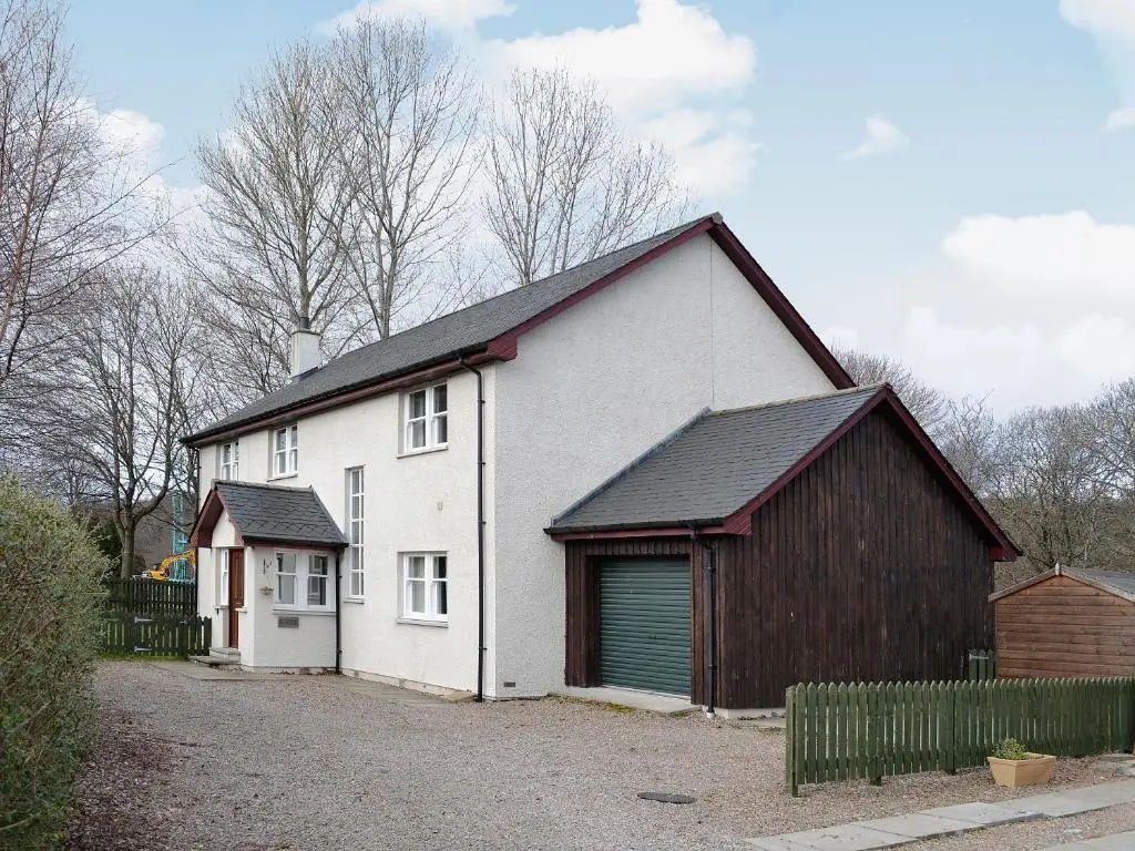 a white house with a gambrel roof and a garage at Haugh House in Aberlour