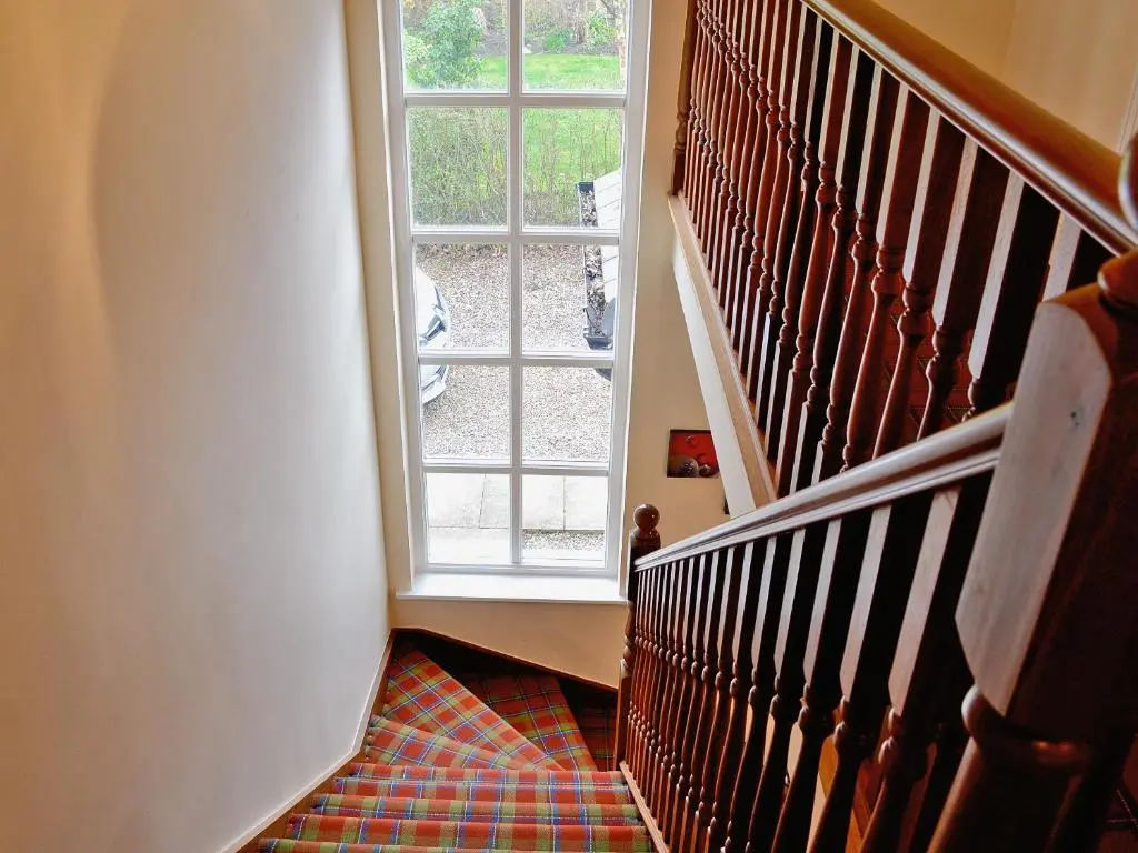 a hallway with a staircase with a window at Haugh House in Aberlour