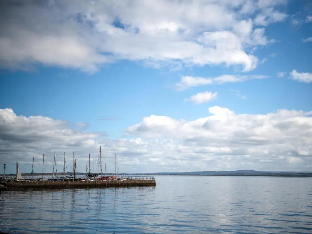 a group of boats docked at a dock on the water at By The Sea in Avoch