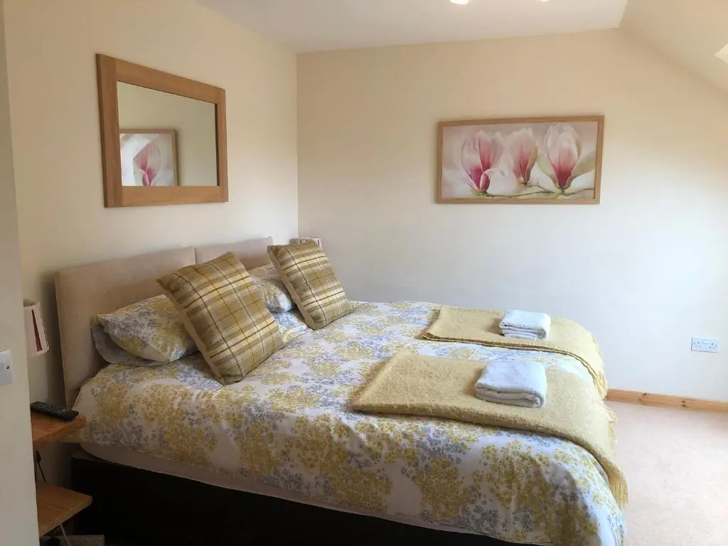 a bedroom with a bed with two towels on it at Tulach Ard in Grantown on Spey
