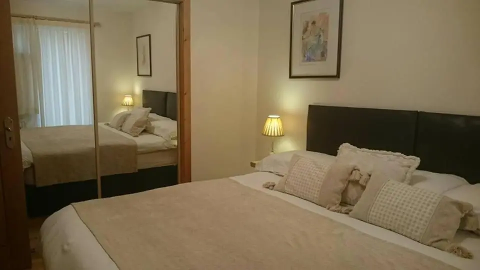 a bedroom with a large bed and a mirror at Tulach Ard in Grantown on Spey