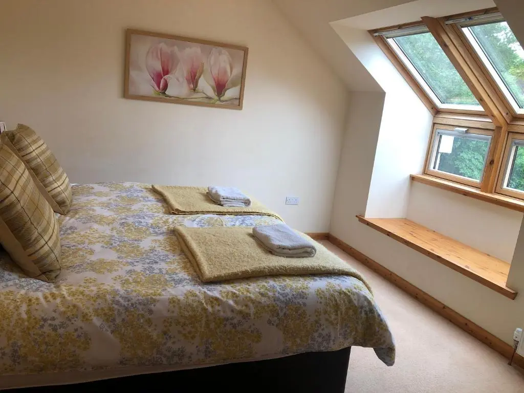 a bedroom with a bed and two windows at Tulach Ard in Grantown on Spey