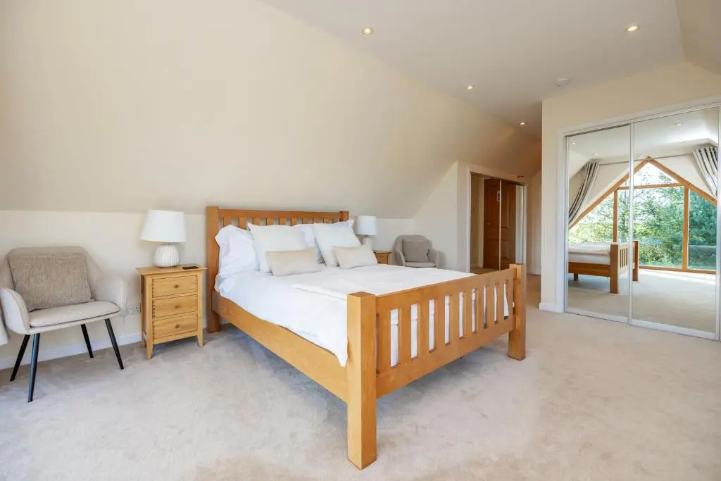 a bedroom with a bed and a chair and a window at Stunning Country House - Cinema, Games Room & Hot Tub in Inverurie