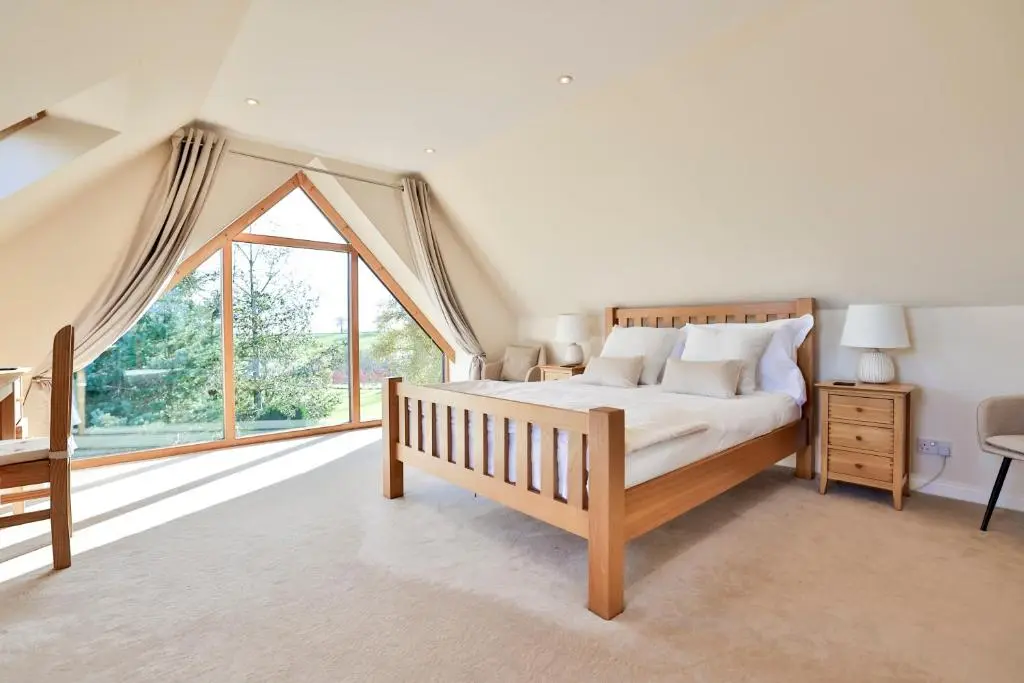 a bedroom with a bed and a large window at Stunning Country House - Cinema, Games Room & Hot Tub in Inverurie