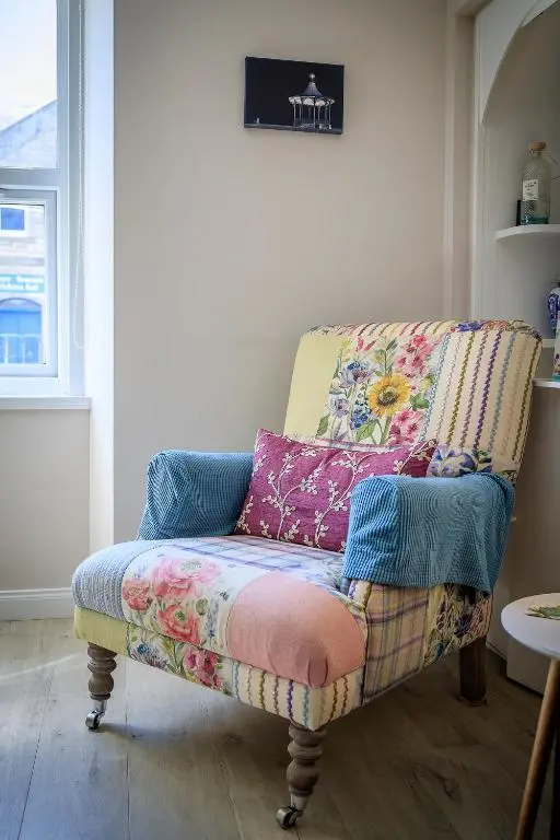 a couch with a colorful blanket on it in a room at Cosy Cottage in Fishertown, Nairn - Free Parking & Pets welcome in Nairn