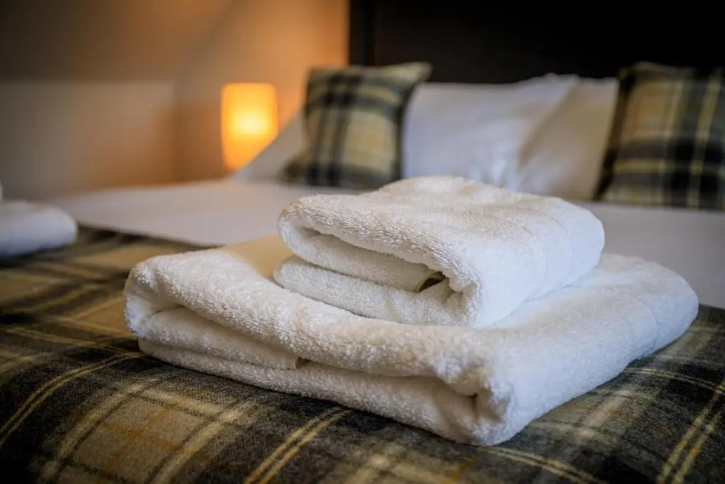 a pile of towels sitting on top of a bed at Cosy Cottage in Fishertown, Nairn - Free Parking & Pets welcome in Nairn